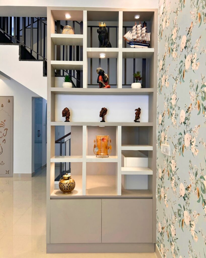 A modern living room display unit with multiple cubby shelves showcasing home decor artifacts designed by the best interior designers in Chennai