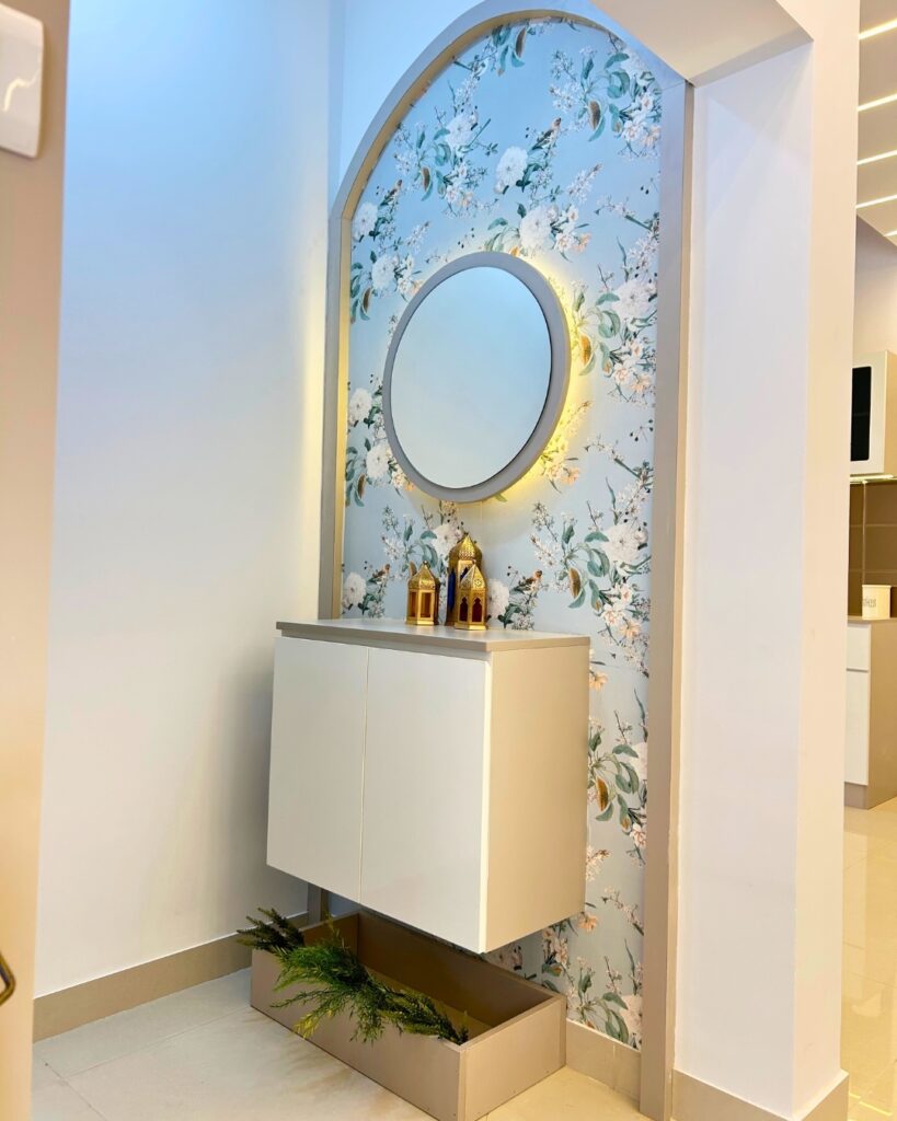 Entrance foyer design with floating white console round backlit mirror and floral wallpaper designed by top interior designers in Chennai
